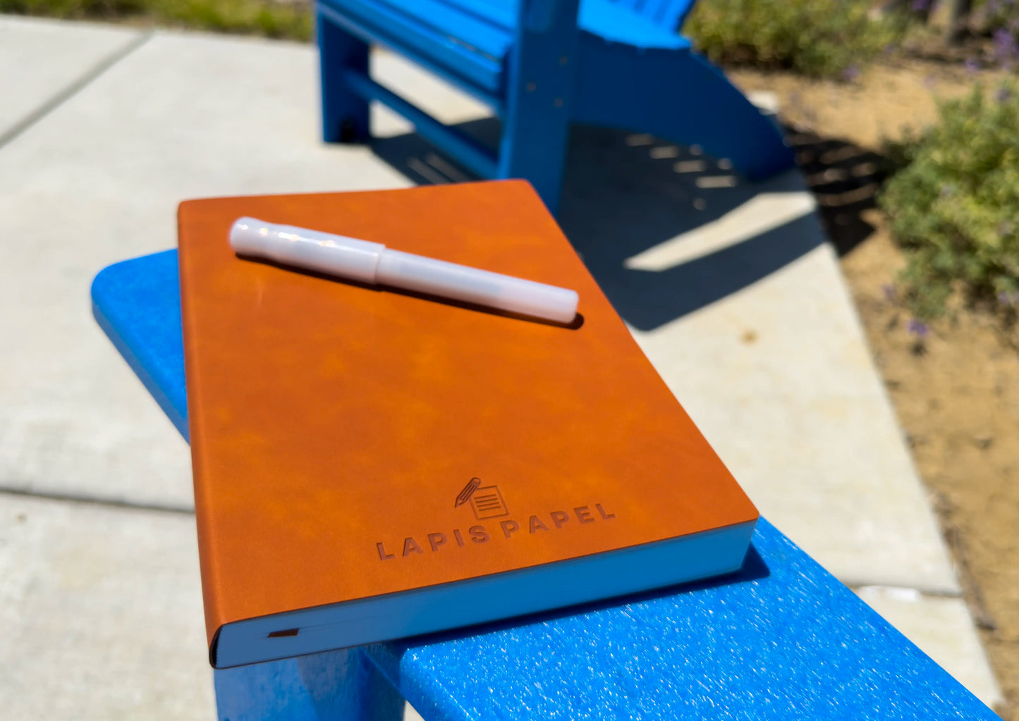 A5 notebook tan on blue chair with pen