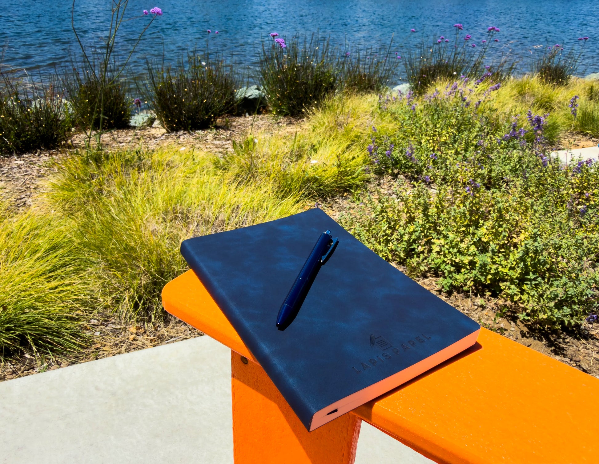 A5 notebook blue on orange chair outside with pen