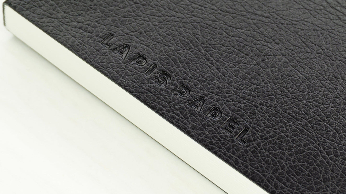 Black A6 notebook with embossed "Lapis Papel" logo on white background